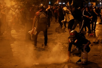 Un manifestante sostiene una bomba