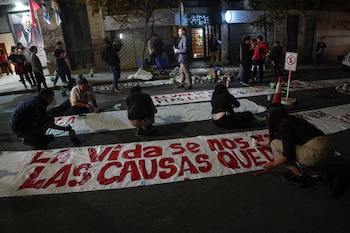 Personas pintan pancartas frente a