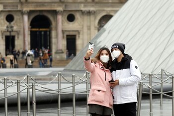 Una pareja que usa máscaras